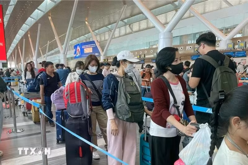 Passengers wait to handle boarding procedures at Tan Son Nhat International Airport. (Photo: VNA)