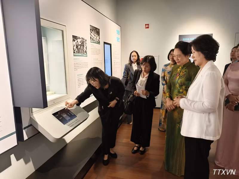 Spouse Nguyen Thi Thanh Nga listens to an introduction to exhibition technology at the RoK Museum. (Photo: VNA)