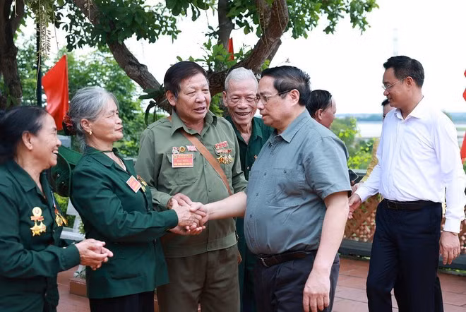 Prime Minister Pham Minh Chinh meets with former youth volunteers and frontline workers at the Truong Son Martyrs Memorial Temple - Long Dai Ferry Terminal site. (Photo: VNA)