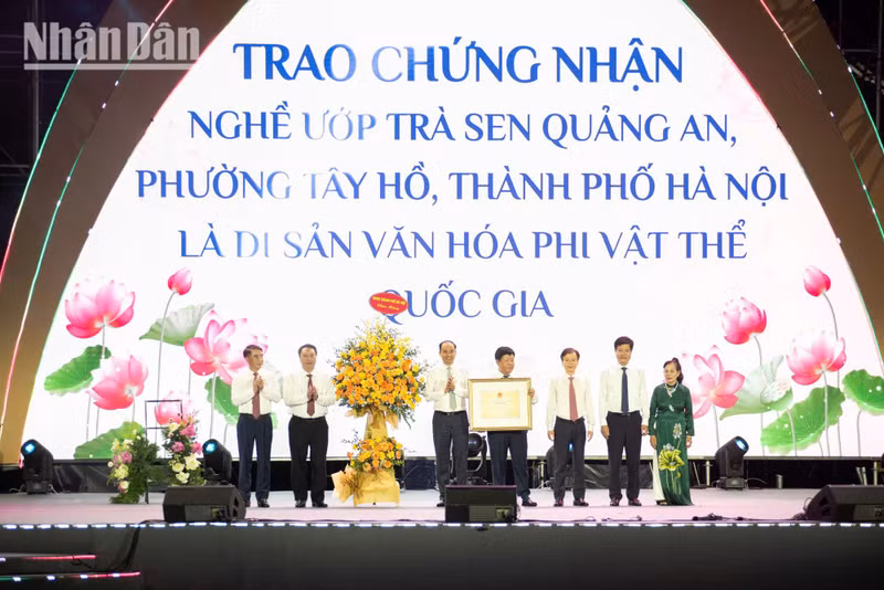 The certificate recognising Quang An Lotus Tea Scenting Craft as a National Intangible Cultural Heritage is presented to artisan Luu Hong Lien.