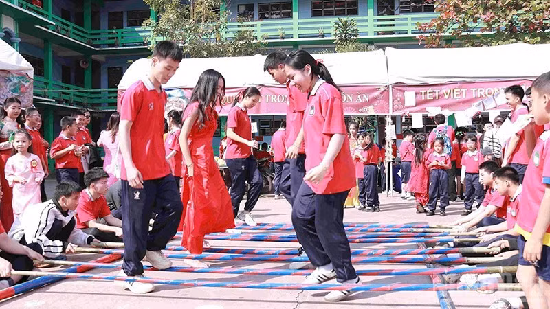 Schoolchildren join a bamboo pole dance at the festival