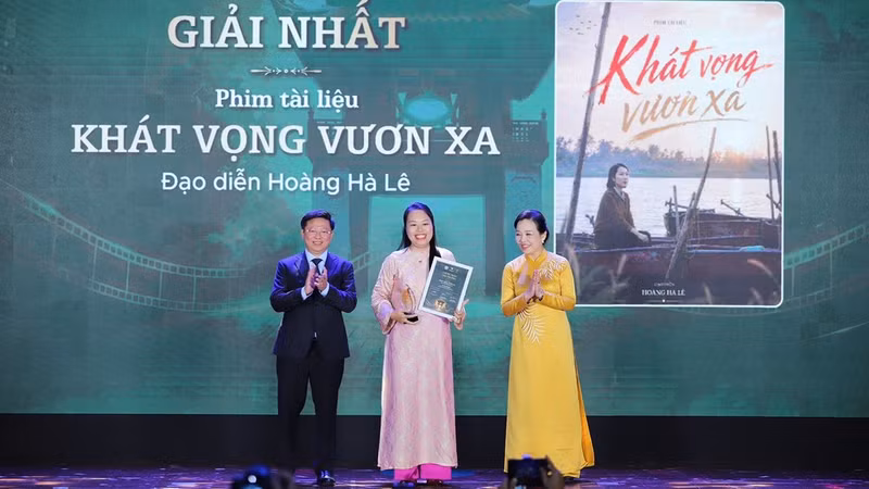 Director Hoang Ha Le (C) receives the first prize at the award ceremony 