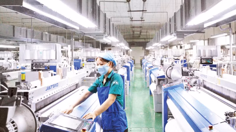 A worker inspects the operation of automated weaving machines at Textile Factory – Corporation 28, under the General Department of Logistics and Technology.