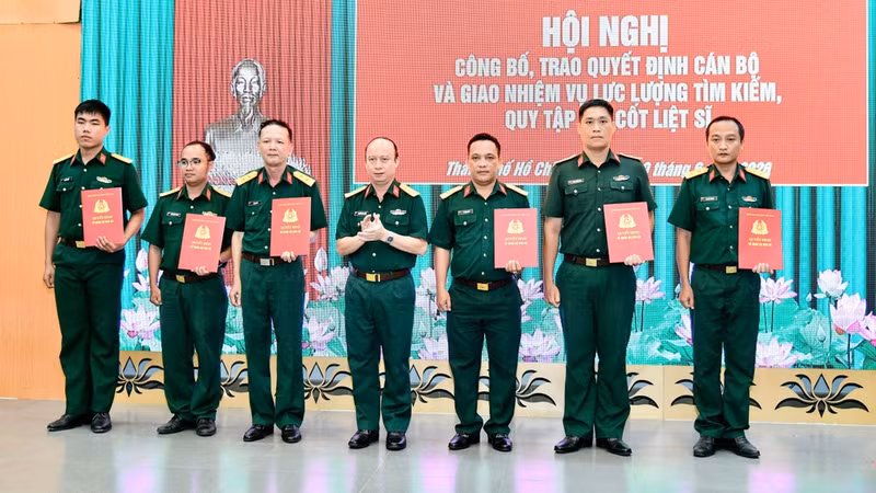 Colonel Nguyen Dinh Chuan, Deputy Political Commissar of the municipal Military Command and Deputy Head of the Ho CHi Minh City’s Steering Committee 515, hands over decisions to assign personnel to the specialised force tasked with searching for and recovering the remains of fallen soldiers. (Photo: NDO)