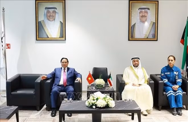 Prime Minister Pham Minh Chinh (left) meets with a leader of the Al-Zour Refinery (Photo: VNA)