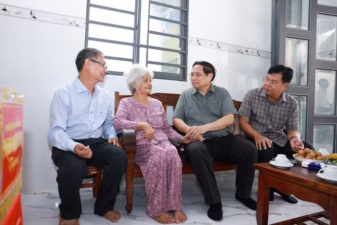 PM Pham Minh Chinh (second from right) visits 85-year-old Nguyen Thi Co (second from left), a revolution contributor in Binh My commune of An Giang province, on July 20. (Photo: VNA)