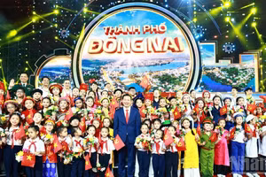 Leaders of Dong Nai city pose for a commemorative photograph with young people and children at the ceremony announcing the establishment of the city on the evening of May 18, 2026.