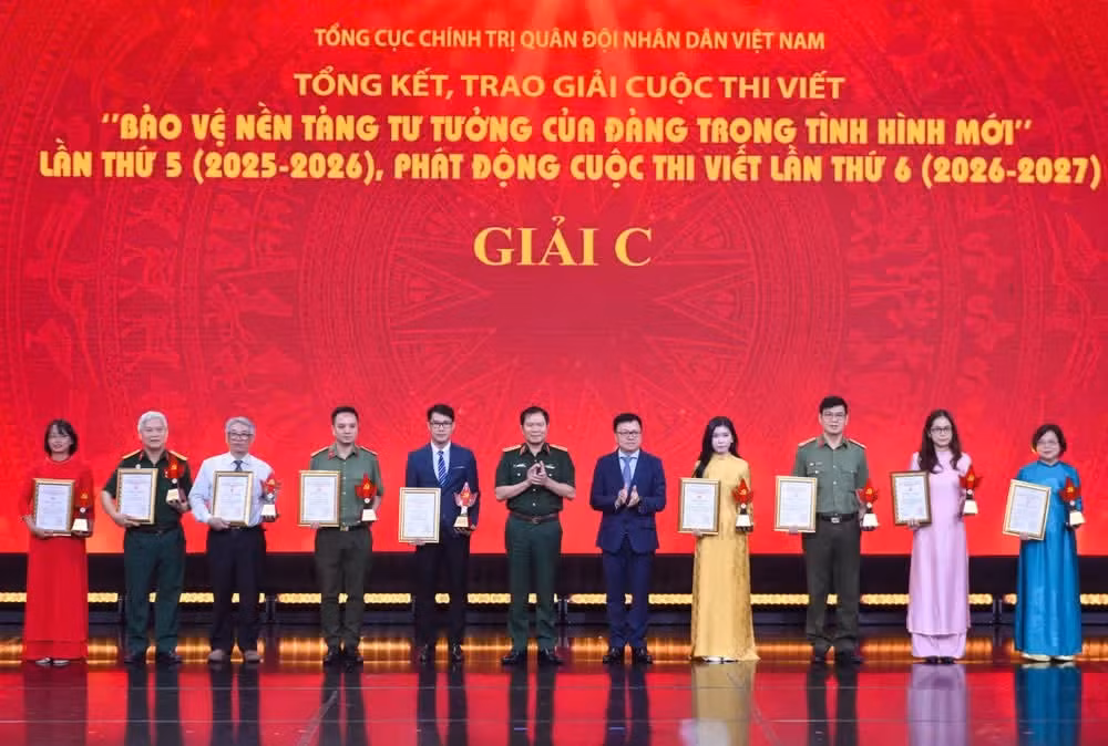 General Nguyen Tan Cuong and Le Quoc Minh, Member of the Party Central Committee, Editor-in-Chief of Nhan Dan Newspaper, and Deputy Head of the Party Central Committee's Commission for Information, Education and Mass Mobilisation, and President of the Viet Nam Journalists Association, presented C prizes to winning authors and author groups.