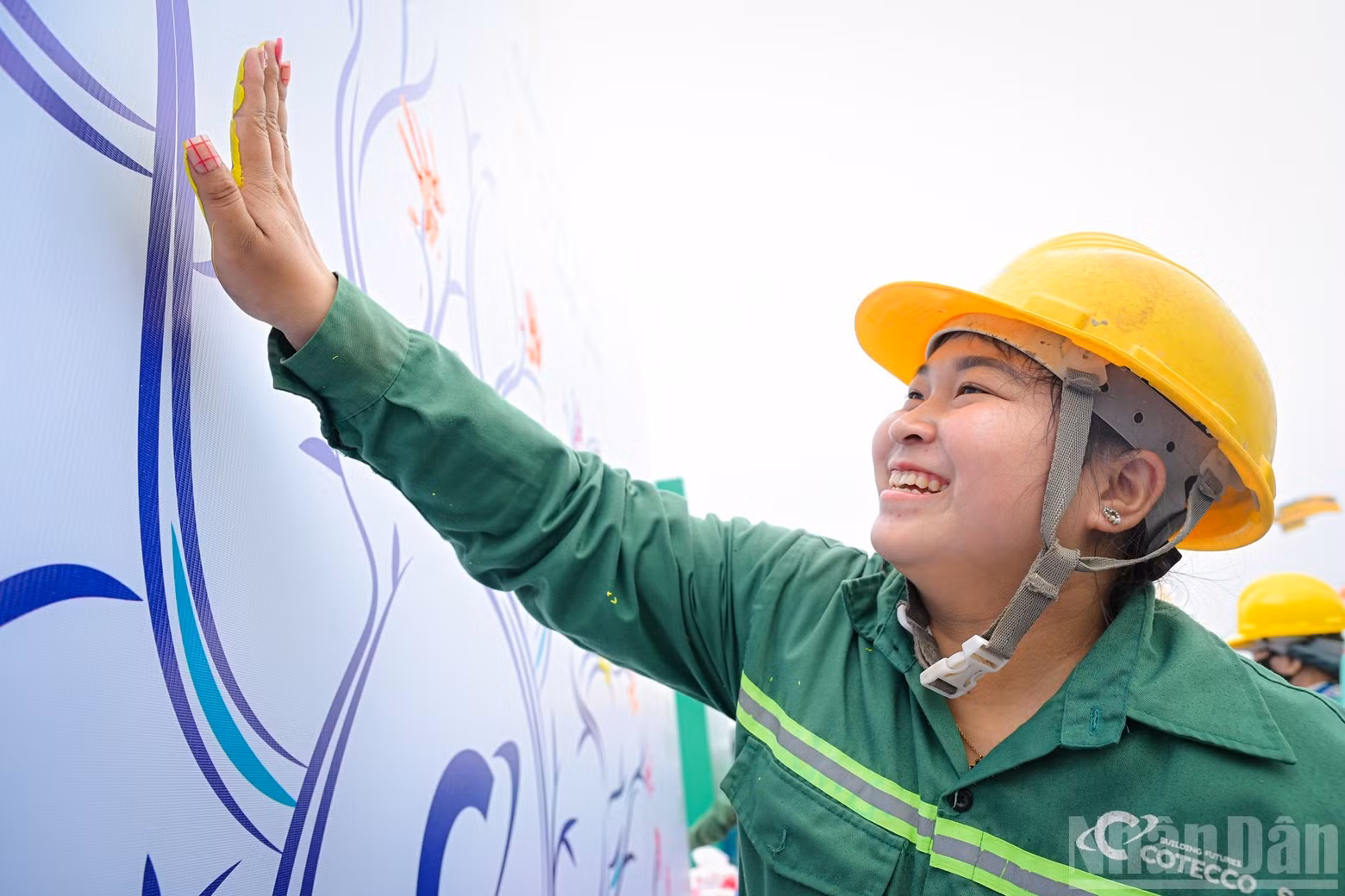 The joy of a female worker as she commits to ensuring safety by placing her handprint on the Safety Tree at the programme.