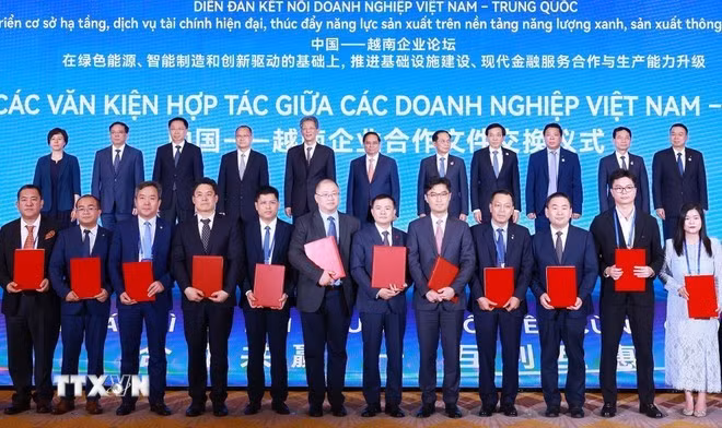 In the presence of Prime Minister Pham Minh Chinh and other delegates, Vietnamese and Chinese companies exchange nine cooperation and investment agreements. (Photo: VNA)
