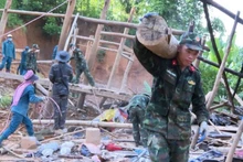 Military officers help people relocate their property to safety.