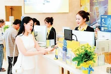 A Nam A Bank teller offers advice to a customer.