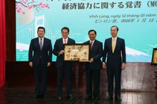 Secretary of the Vinh Long Party Committee Tran Van Lau (second from right) presents a gift to Ehime Governor Tokihiro Nakamura at the MoU signing ceremony on January 12. (Photo: VNA)