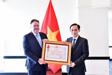 Foreign Minister Le Hoai Trung presents the Friendship Order to US Ambassador Marc Knapper. (Photo: VNA)