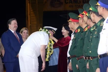 US officers and sailors are greeted with flowers. (Photo: VNA)