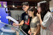 Readers experience e-books at the exhibition on national achievements at the Viet Nam Exposition Centre in Dong Anh, Ha Noi.