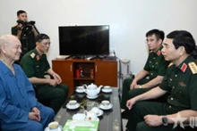 Minister of Defence Phan Van Giang inquires after former Defence Minister Pham Van Tra. (Photo: QDND)
