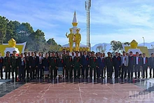 Delegates pose for a photo in front of the Laos-Viet Nam fighting alliance monument in Xaysomboun Province. (Photo: Duy Toan)