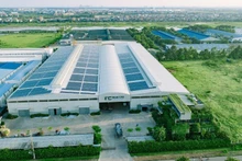 Rooftop solar panels are installed at a manufacturing facility to reduce electricity costs.