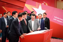 Deputy Prime Minister Mai Van Chinh, Party General Secretary and President of Laos Thongloun Sisoulith, and President of the Cambodian People’s Party and President of the Cambodian Senate Hun Sen visit a space of the Nhan Dan Newspaper at the exhibition on September 2. (Photo: NDO)
