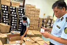 Market management forces in Ha Noi City inspect goods with signs of violations in e-commerce activities. (Photo: HOANG YEN)