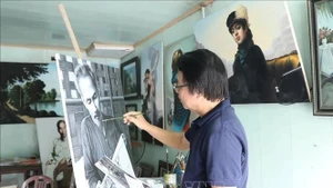 Artist Tran Hoa Binh paints a portrait of President Ho Chi Minh. (Photo: VNA)