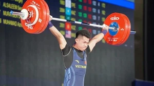 Tran Minh Tri lifts the barbel during the men's 67kg category in the Asian Weightlifting Championships 2025. (Photo: VNA)