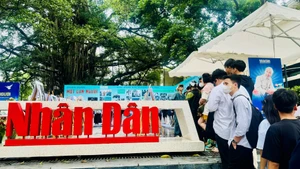 A large number of young people queue to visit the exhibition and receive the special edition dedicated to President Ho Chi Minh. (Photo: HNV)