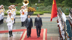 State President Luong Cuong and French President Emmanuel Macron inspect the Guard of Honour of the Viet Nam People's Army