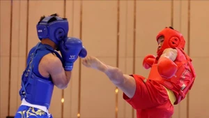 Bui Truong Giang (in red) brought home the fourth gold for Vietnamese Wushu team after taking down Gideon Fred Wayan Padua of the Philippines in combat event. (Photo: VNA)