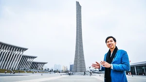 Architect Trinh Viet A beside the monumental structure designed by him and his colleagues.