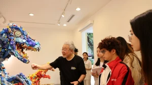 Artist Hiroshi Fuji introduces his artworks to visitors at the exhibition 