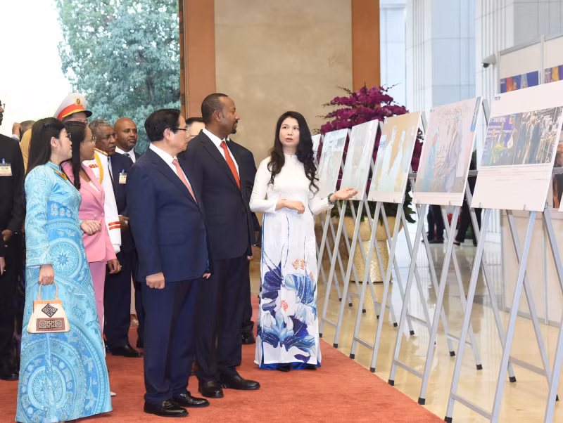 The two PMs tour a photo exhibiton on bilateral relations held by the Vietnam News Agency (Photo: NDO)