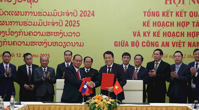 Luong Tam Quang, Politburo member, Minister of Public Security of Vietnam and Vilay Lakhamphong, Politburo member, Deputy Prime Minister, Minister of Public Security of Laos sign the cooperation agreement between the two countries’ Ministries of Public Security. (Photo: KHONG HA)