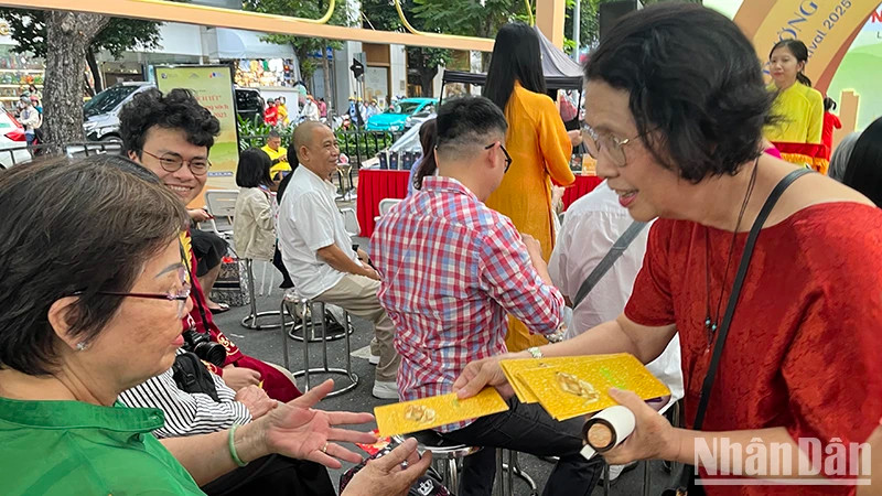 Dr Quach Thu Nguyet gives books to people attending the programme.