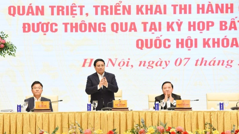 Prime Minister Pham Minh Chinh (C) chairs a conference on March 7 on the implementation of laws and resolutions adopted at the 9th extraordinary session of the 15th National Assembly. (Photo: NDO)
