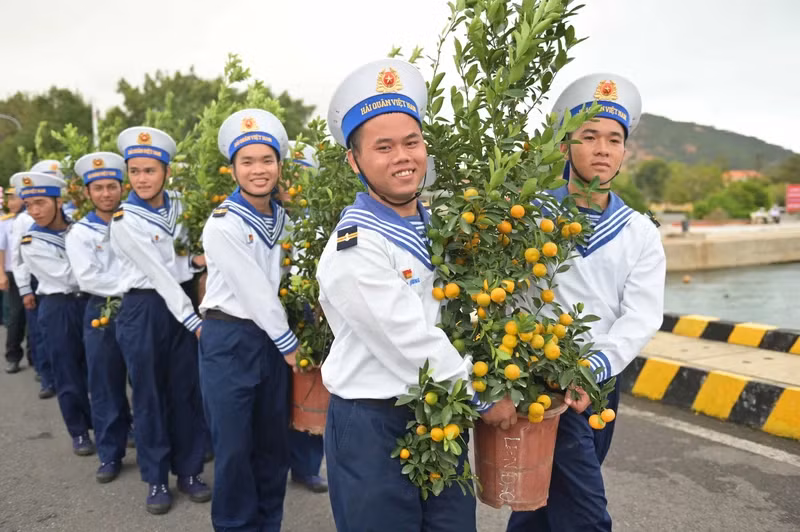 Navy soldiers bring kumquat pots to the island. (Photo: Doan Van Truong)