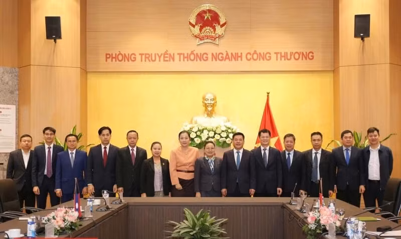 Minister of Industry and Trade Nguyen Hong Dien (6th from right) and Lao Ambassador to Vietnam Khamphao Ernthavanh (7th from right) have a working session in Hanoi on January 3. (Photo: tapchicongthuong.vn)