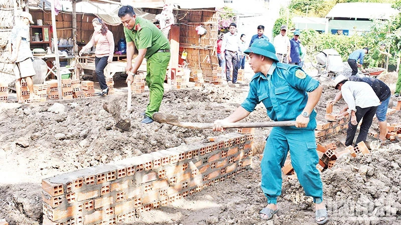 Armed forces and political organisations of Huyen Hoi Commune, Cang Long District, Tra Vinh Province, support people to build houses. (Photo: KHOI - GIANG)
