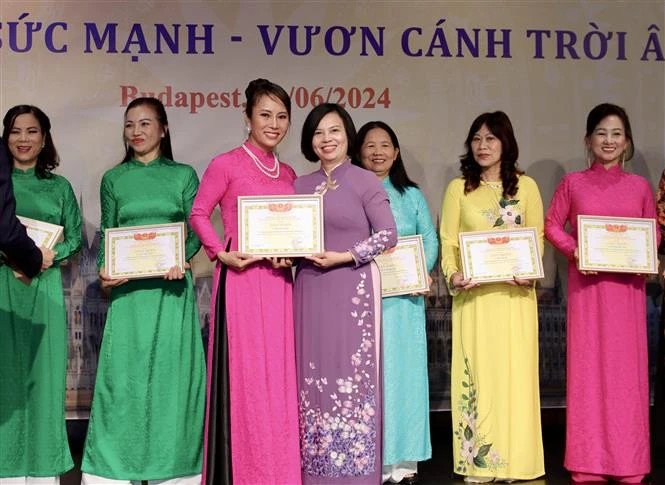 Ambassador Nguyen Thi Bich Thao presents certificates of merit to members of the Vietnamese women's union in Hungary for their contributions to its activities. (Photo: VNA)
