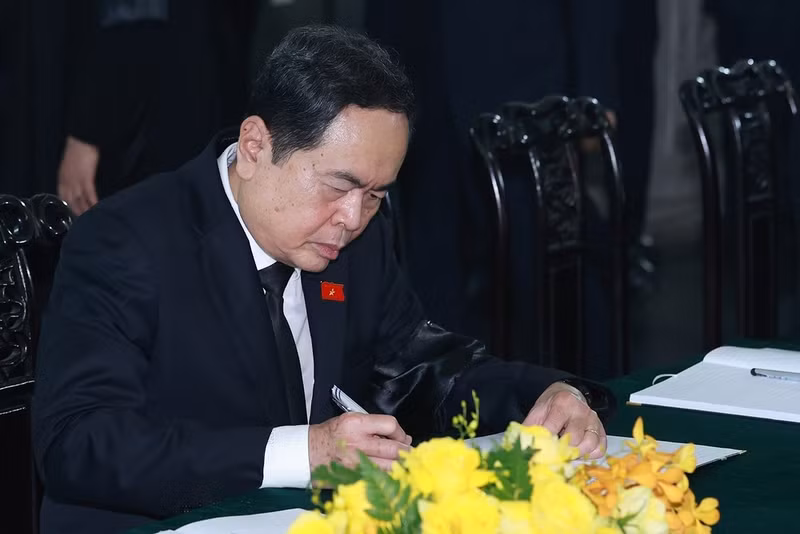 Politburo member and National Assembly Chairman Tran Thanh Man writes in the book of condolences. (Photo: VNA)