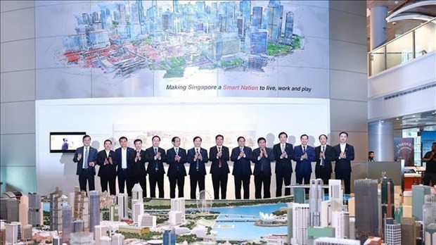 Prime Minister Pham Minh Chinh and officials visit the Singapore Smart National Exhibition. (Photo: VNA) 