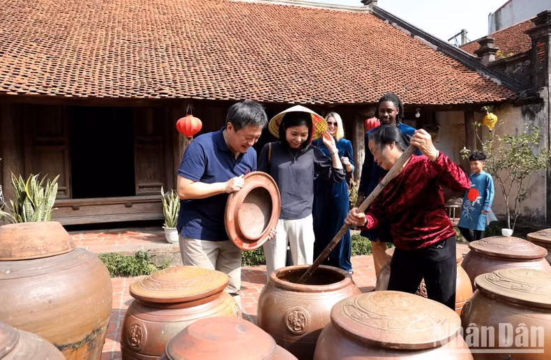 Visitors learn about the traditional craft of making soy sauce in Duong Lam village.