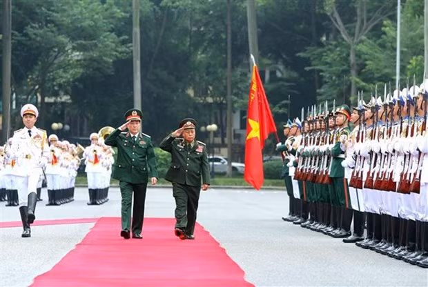 Gen. Luong Cuong, Chairman of the VPA’s General Department of Politics, and Sen. Lieut. Gen. Thongloi Silivong inspect the guard of honour. (Photo: VNA)