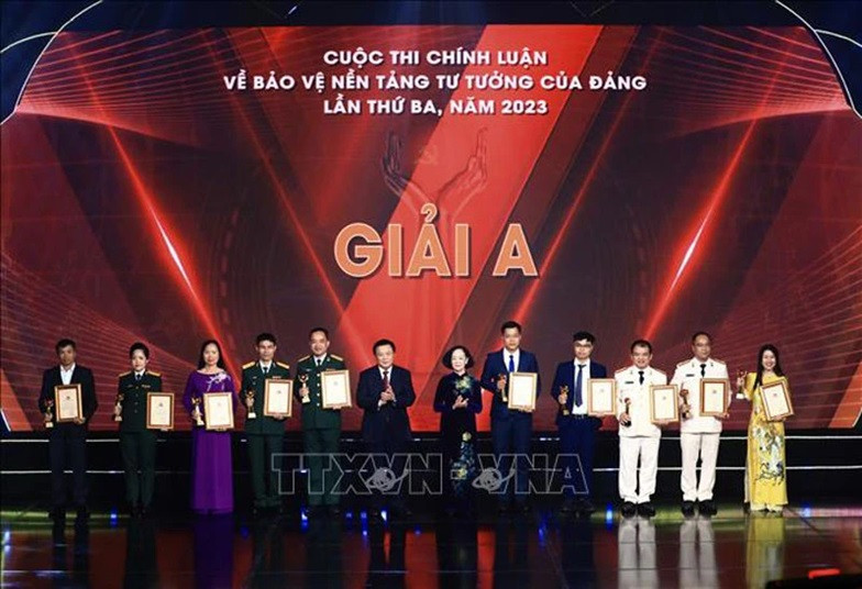 Politburo member, Permanent member of the Party Central Committee (PCC)’s Secretariat and Head of the PCC’s Organisation Commission Truong Thi Mai and Politburo member, Director of the Ho Chi Minh National Academy of Politics and Chairman of the Central Theoretical Council Nguyen Xuan Thang present A prizes to the winners.