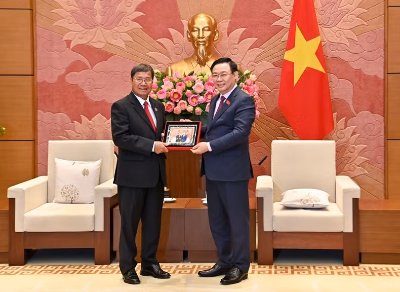 NA Chairman Vuong Dinh Hue presents a souvenir to Lao NA Vice Chairman Khambay Damlath.