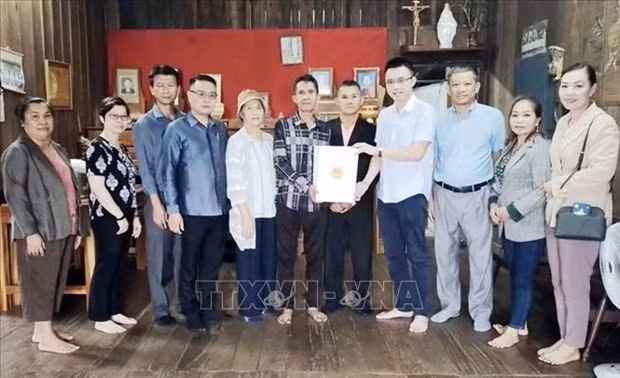 Representatives from the Vietnamese Consulate General in Pakse city present gifts to families of invalids and martyrs in Champasak province. (Photo: VNA) 