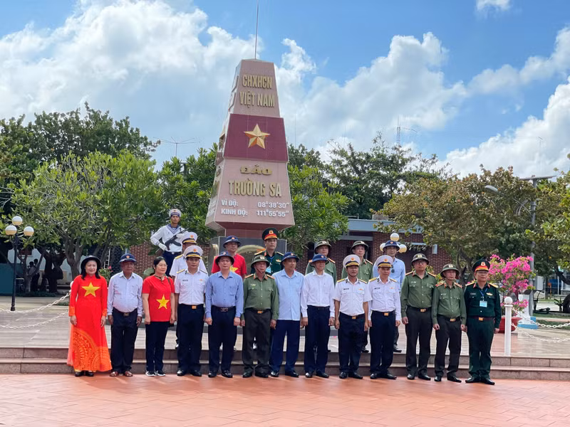 Colonel Hoang Luong Ngoc (top row, fourth from right) and the delegation's representative took souvenir photos at the sovereignty landmark on Truong Sa.