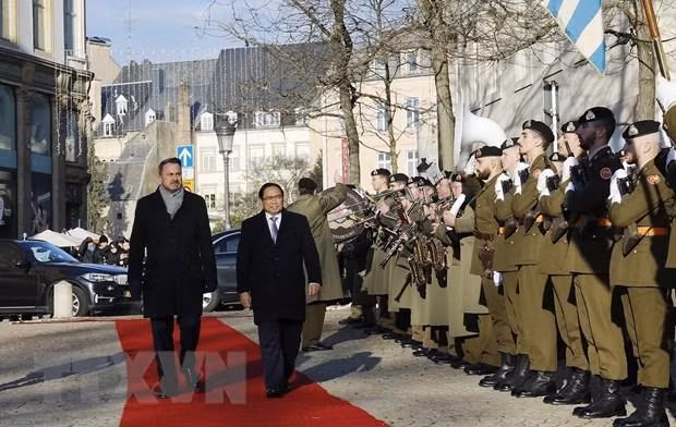Prime Minister Pham Minh Chinh (R)and his Luxembourg counterpart Xavier Bettel review the honor guard (Photo: VNA)