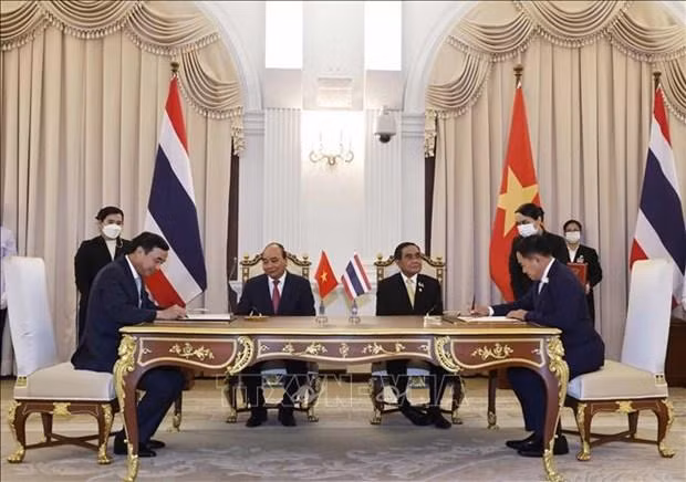 President Nguyen Xuan Phuc (sitting, left) and Prime Minister Prayut Chan-o-cha (sitting, right) witness the signing of the Memorandum of Understanding (MoU) on the Establishment of Sister City Relationship between and Thailand’s Khon Kaen province and Vietnam’s Da Nang city. (Photo: VNA)